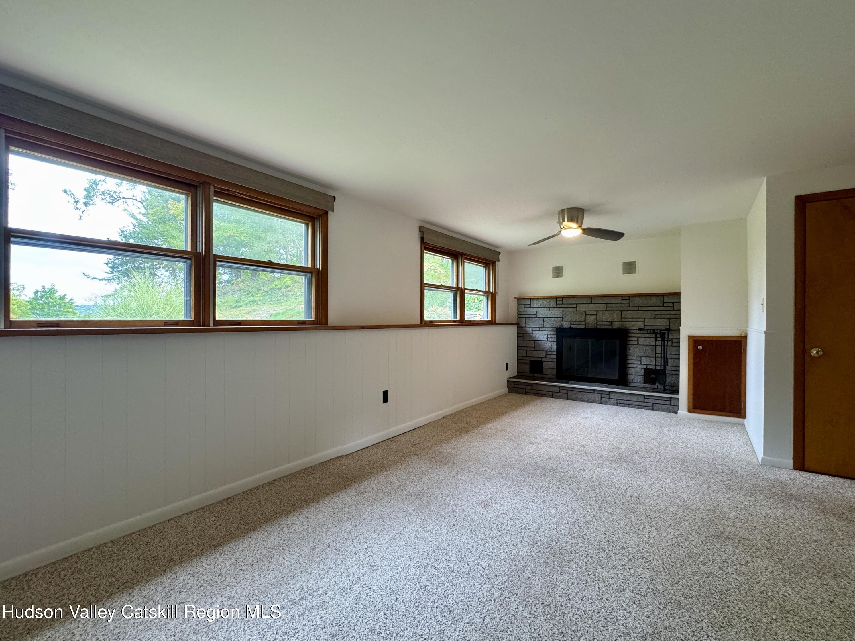 399 Hamburg Road Catskill, NY 12414 - Photo 7 of 23 an empty room with fireplace and windows