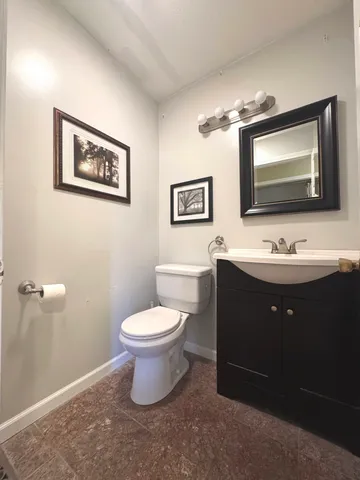 a bathroom with a toilet a sink and mirror