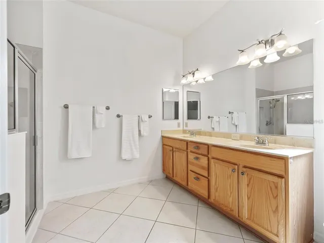 a spacious bathroom with a double vanity sink a mirror and a shower