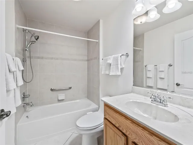 a bathroom with a granite countertop sink a toilet and shower