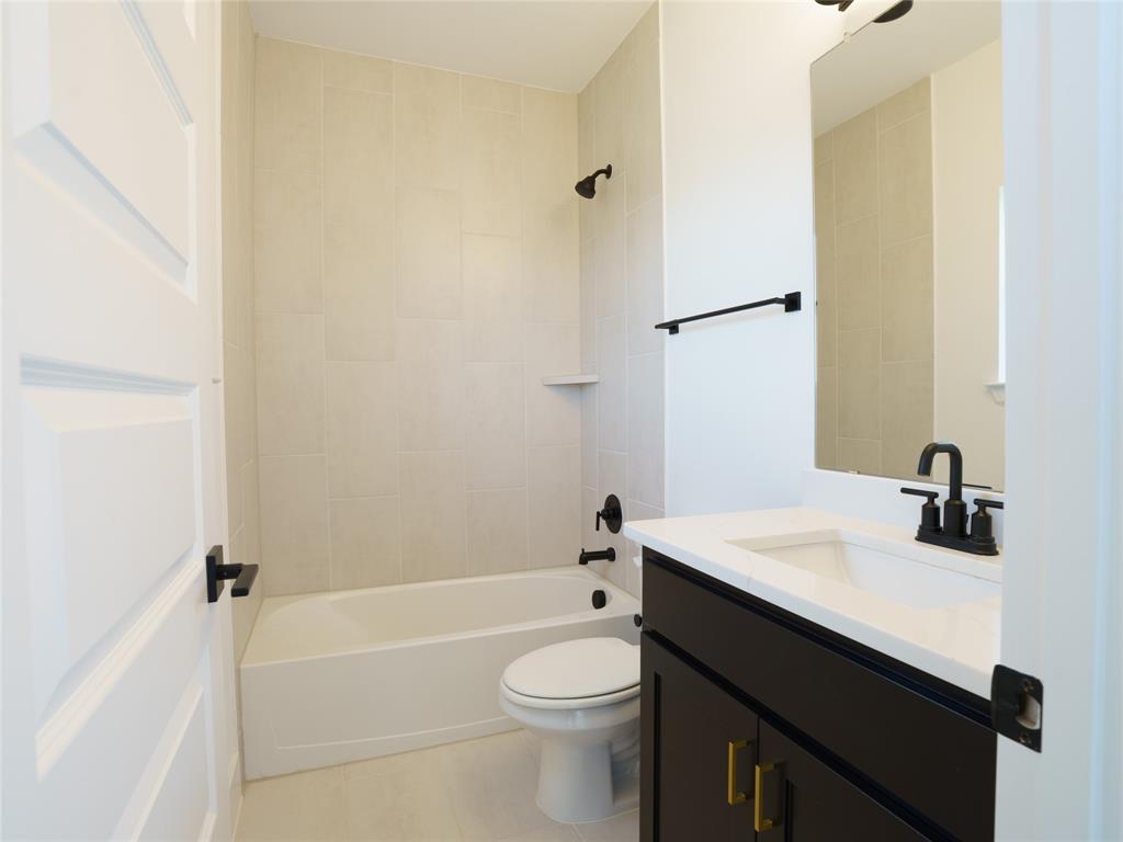 9311 Easy Street Rowlett, TX 75088 - Photo 14 of 22 Bathroom with vanity, washtub / shower combination, and light tile patterned floors