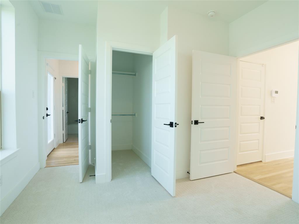 9311 Easy Street Rowlett, TX 75088 - Photo 15 of 22 Unfurnished bedroom featuring light carpet and a walk in closet
