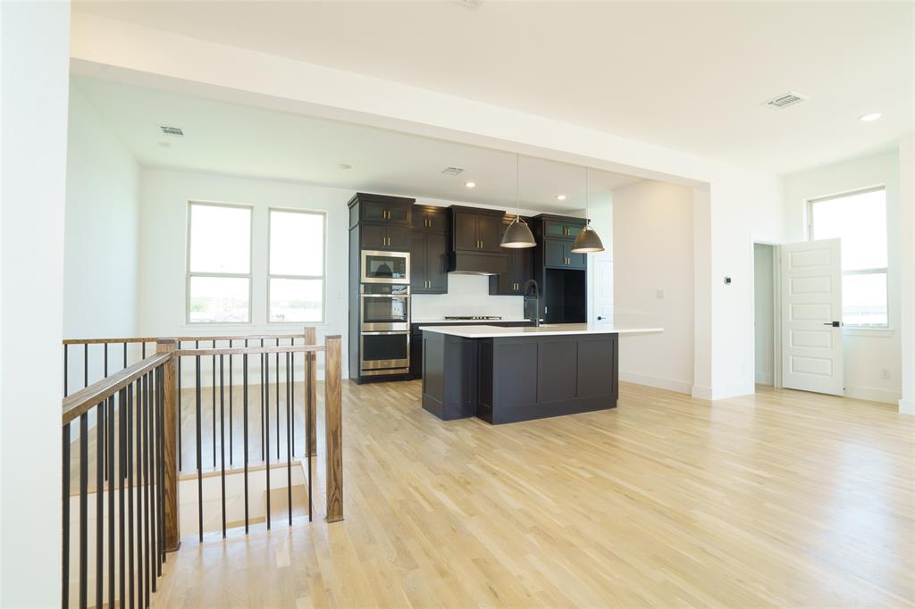 9311 Easy Street Rowlett, TX 75088 - Photo 3 of 22 Kitchen with decorative light fixtures, a kitchen island with sink, light wood-style floors, stainless steel appliances, and recessed lighting