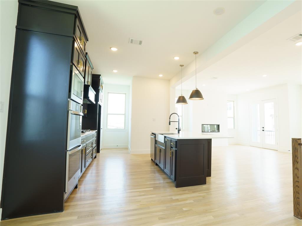 9311 Easy Street Rowlett, TX 75088 - Photo 22 of 22 Kitchen with a kitchen island with sink, pendant lighting, light wood-type flooring, recessed lighting, and open floor plan