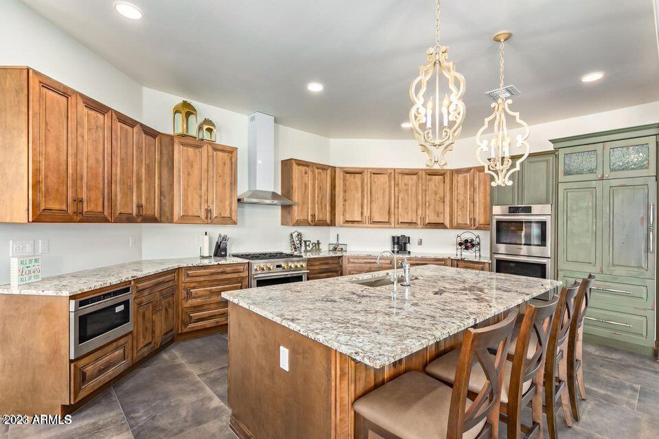 27808 Desierto Drive Rio Verde, AZ 85263 - Photo 15 of 44 a kitchen with stainless steel appliances granite countertop a kitchen island a stove a sink dishwasher a dining table and chairs with wooden floor
