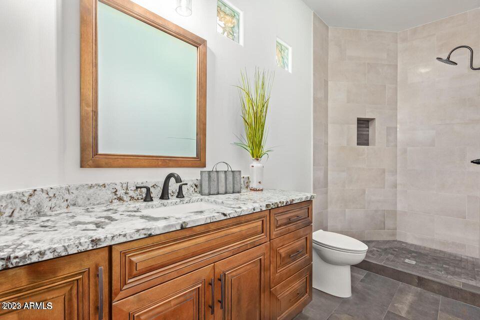 27808 Desierto Drive Rio Verde, AZ 85263 - Photo 28 of 44 a bathroom with a granite countertop sink a toilet and a mirror