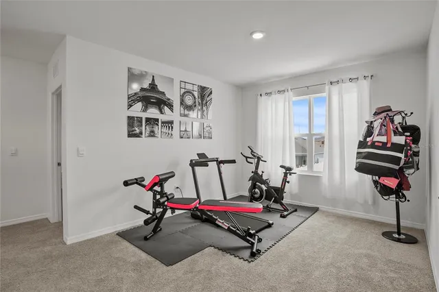 a living room with furniture gym equipment and a window