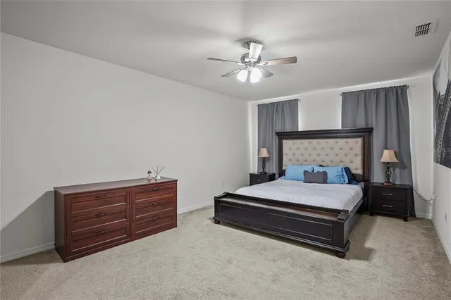 a bedroom with a bed lamp and dresser