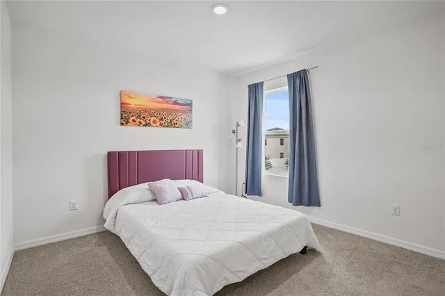 a bed sitting in a bedroom next to a bathroom sink