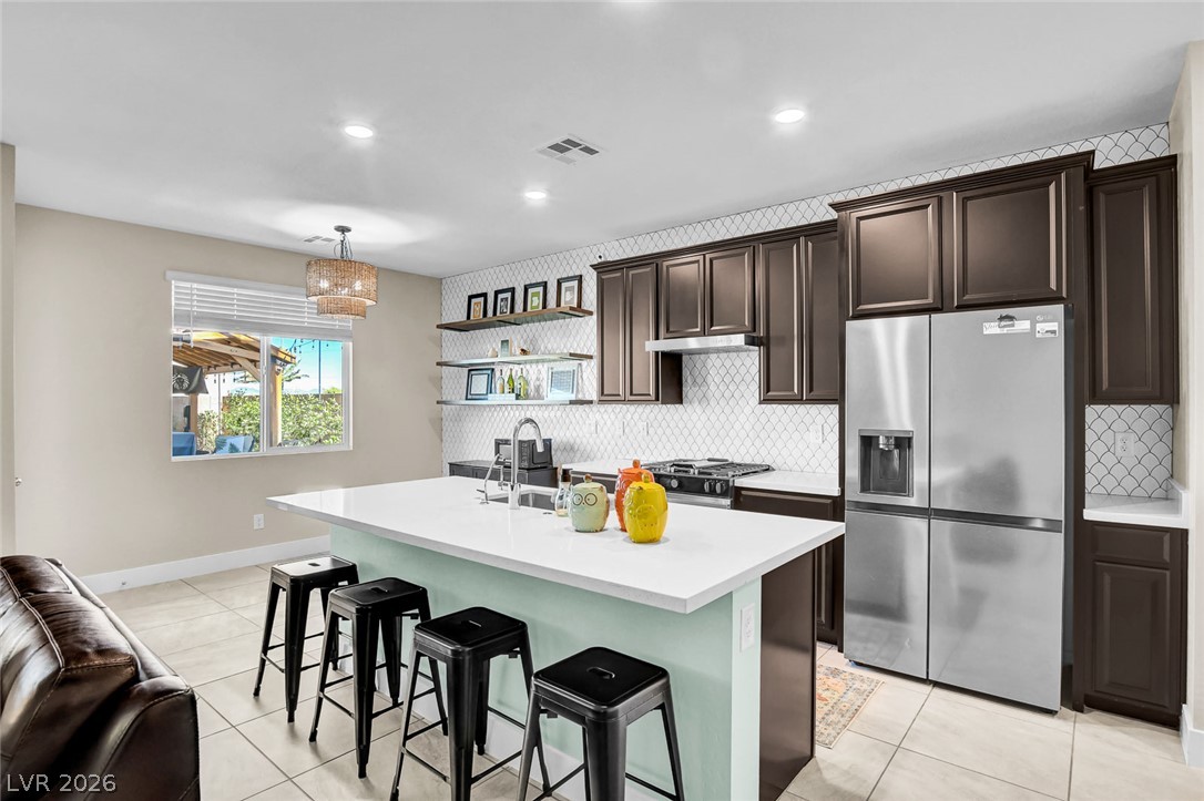 9688 Rankin Rdg Court Las Vegas, NV 89178 - Photo 9 of 53 Culinary adventures await in this kitchen featuring a spacious island and gleaming stainless steel appliances.