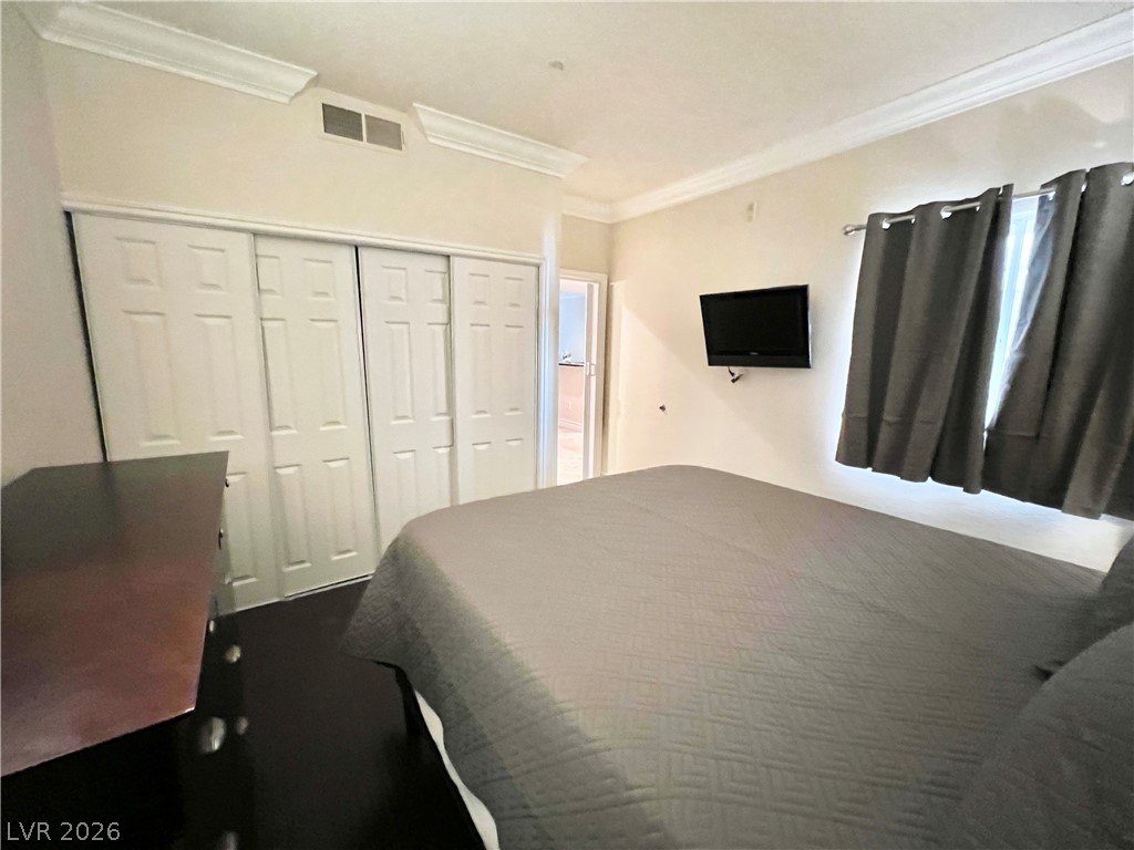 270 East Flamingo Road, Unit 313 Las Vegas, NV 89169 - Photo 16 of 27 Well-lit sleeping quarters with elegant crown molding and ample wardrobe space.