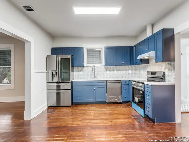 a kitchen with stainless steel appliances granite countertop a refrigerator stove and sink