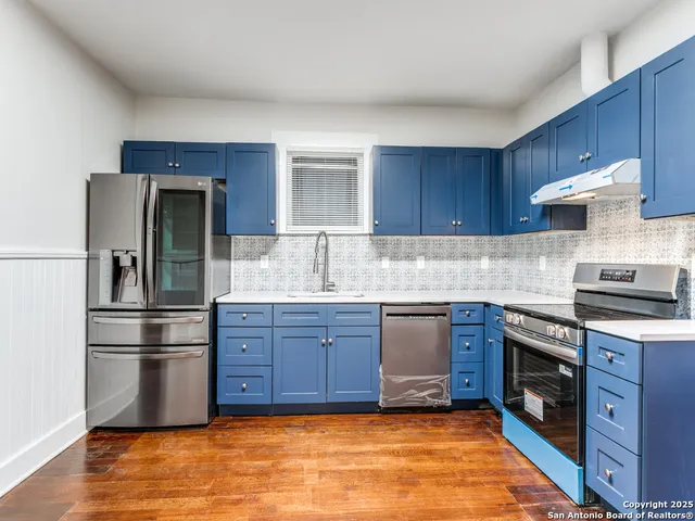 a kitchen with a refrigerator sink and wooden cabinets