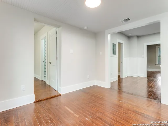 a view of a hallway with wooden floor