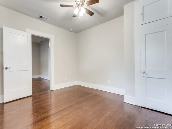 a view of an empty room with wooden floor