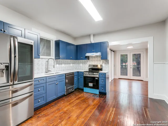 a kitchen with stainless steel appliances granite countertop a refrigerator stove top oven and sink