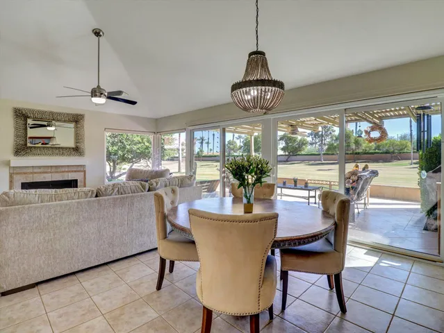 a dining room with furniture a chandelier and window