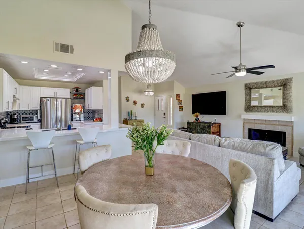 a living room with furniture a chandelier and a flat screen tv