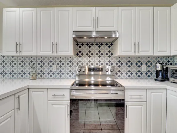 a kitchen with a stove and white cabinets