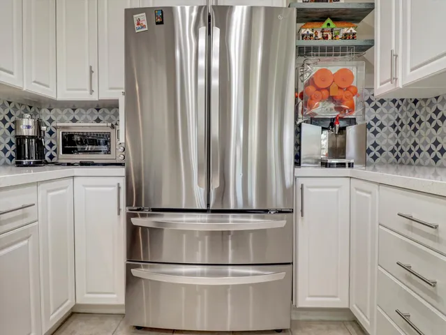 a kitchen with stainless steel appliances granite countertop a refrigerator and a stove