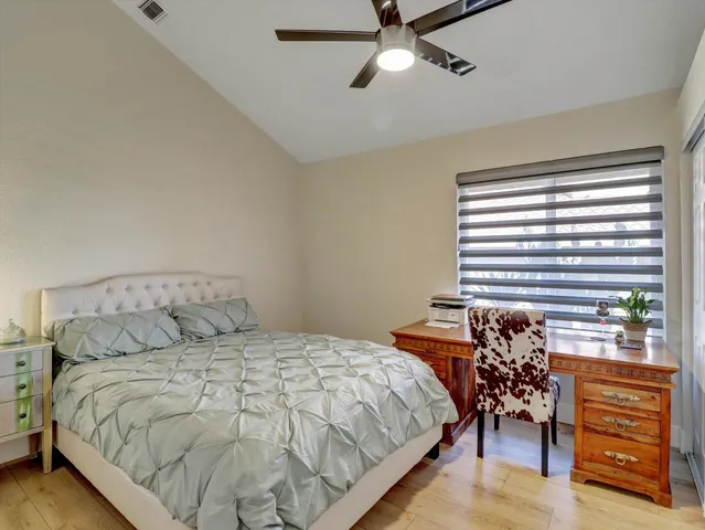a bedroom with a large bed and a chandelier