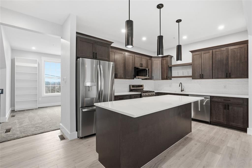 2339 Old Greentree Road Carnegie, PA 15106 - Photo 11 of 48 a kitchen with stainless steel appliances granite countertop a refrigerator a sink a stove a microwave and wooden cabinets