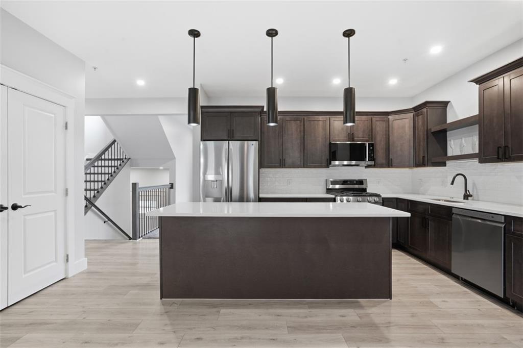 2339 Old Greentree Road Carnegie, PA 15106 - Photo 12 of 48 a large kitchen with stainless steel appliances kitchen island a large counter top and a wooden floors