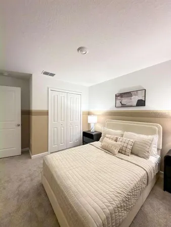 a bedroom with a bed and a night stand