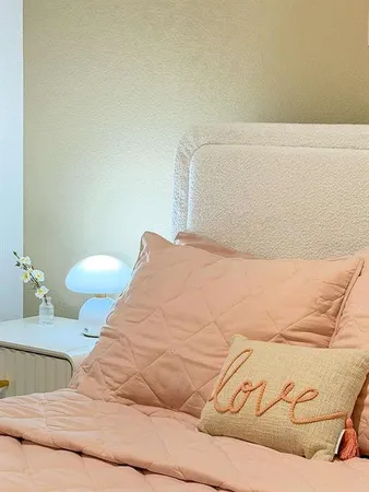 a bedroom with a bed and painting on the wall
