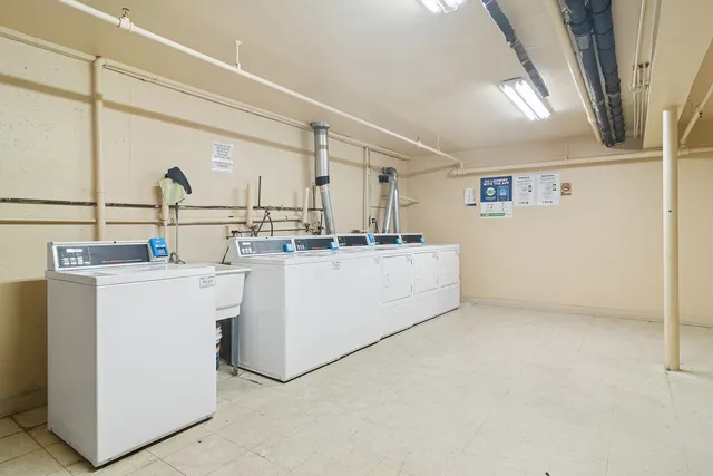 a view of a brick house next to a yard with big trees