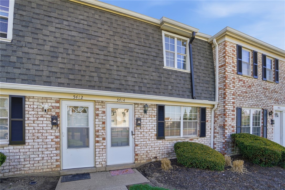 5414 Lamme Road Dayton, OH 45439 - Photo 2 of 32 This charming townhome exterior features classic brick and shuttered windows, blending comfort and timeless appeal.