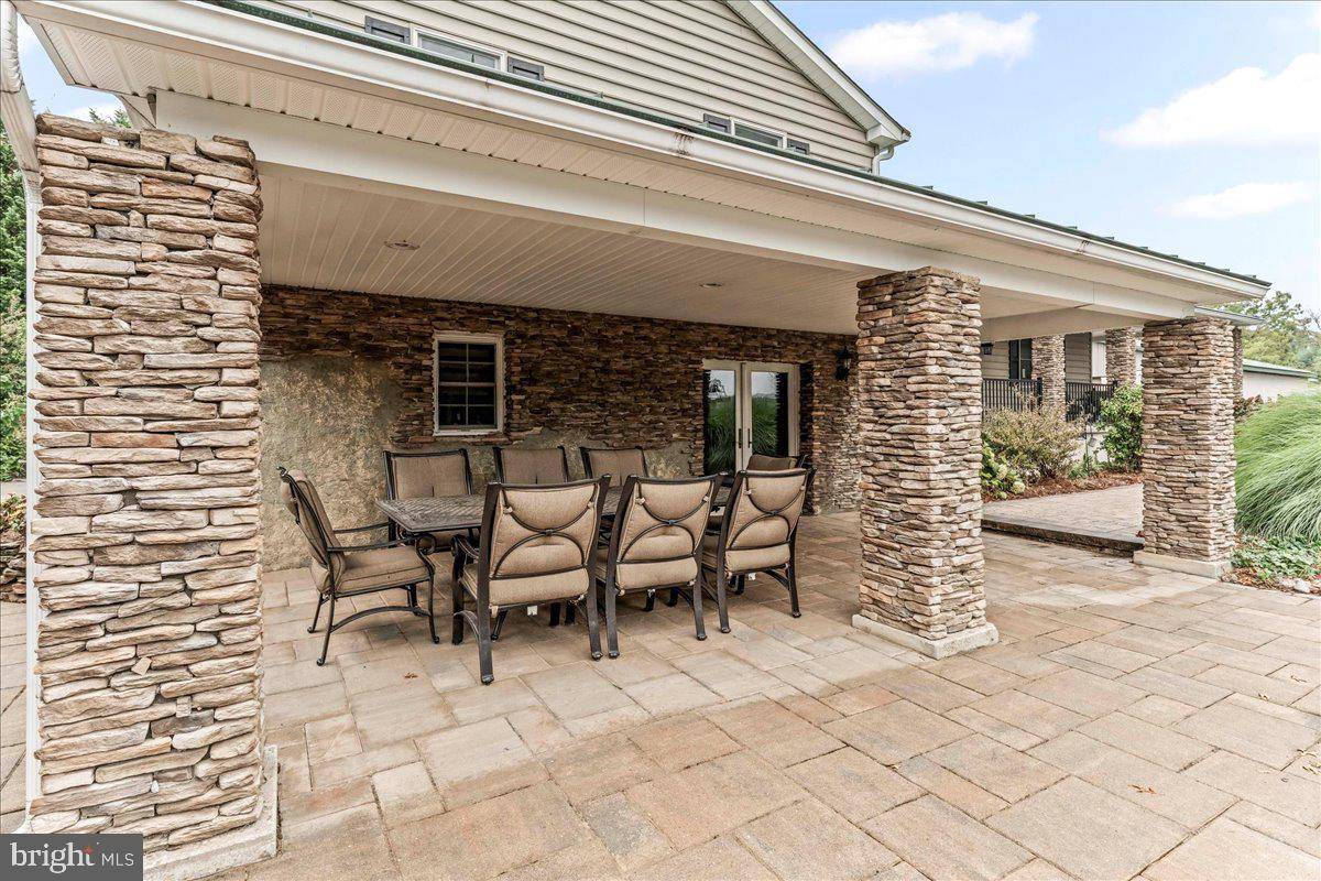 756 Ewing Road Cochranville, PA 19330 - Photo 12 of 73 a view of a patio with table and chairs with wooden floor and fence