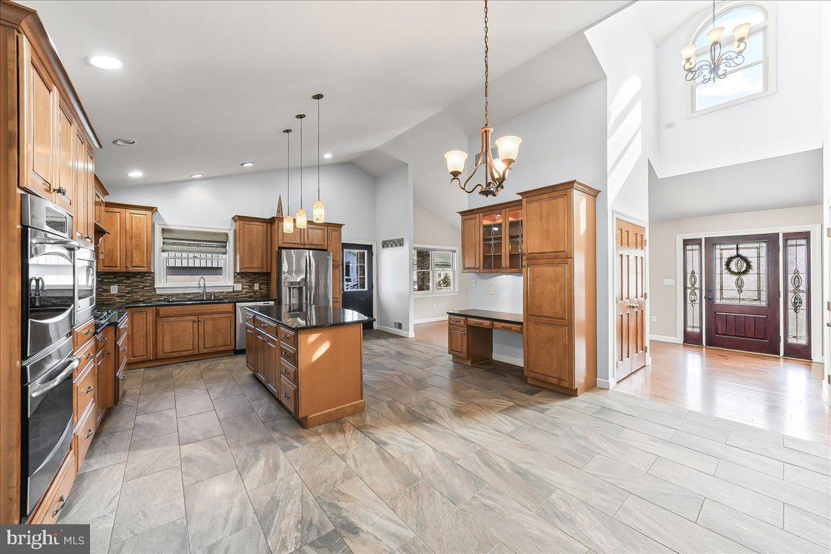 756 Ewing Road Cochranville, PA 19330 - Photo 36 of 73 a kitchen with stainless steel appliances kitchen island granite countertop a refrigerator oven a sink dishwasher and a refrigerator with wooden floor