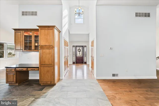 a view of a big room with wooden floor and a kitchen