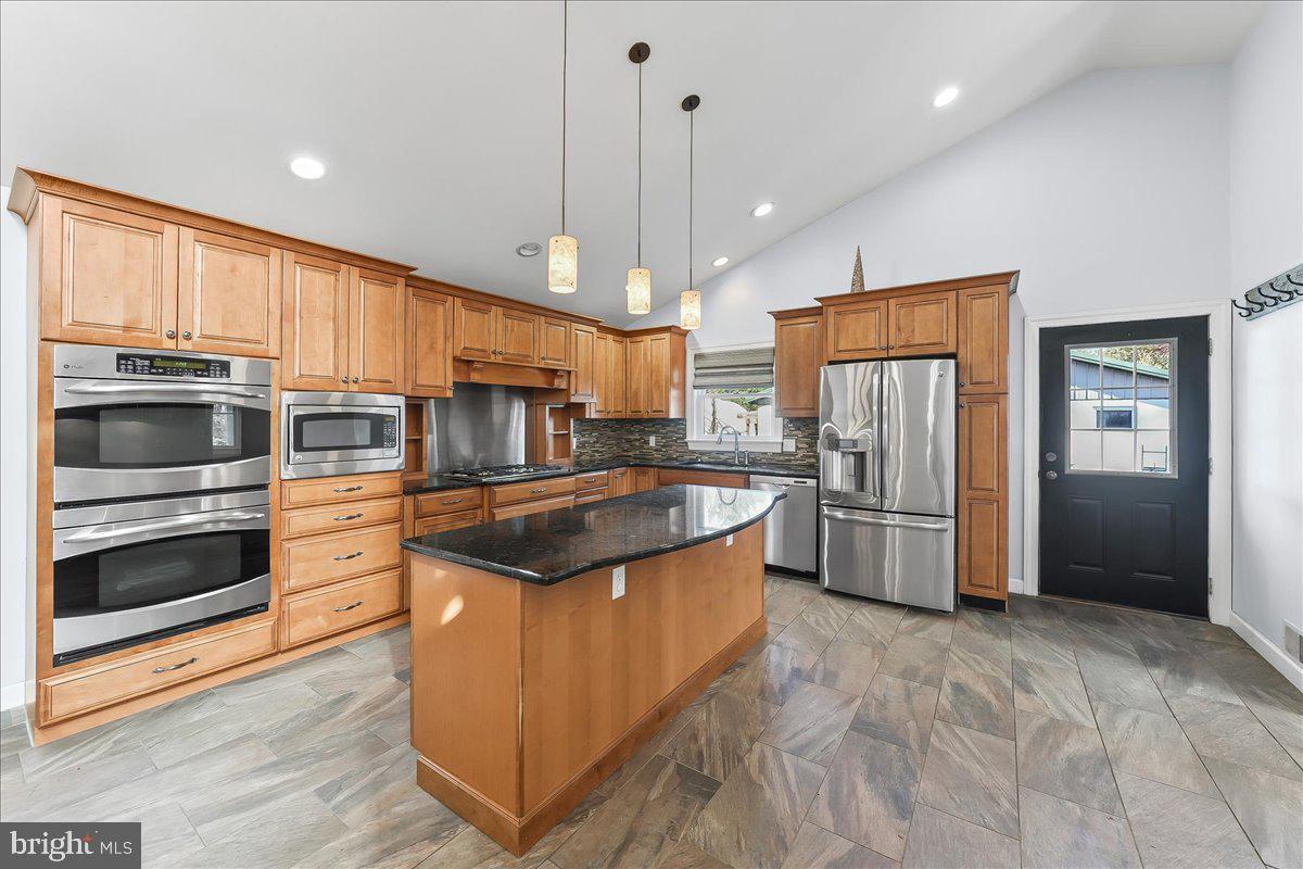 756 Ewing Road Cochranville, PA 19330 - Photo 38 of 73 a kitchen with stainless steel appliances granite countertop a stove a refrigerator and a sink with wooden floors