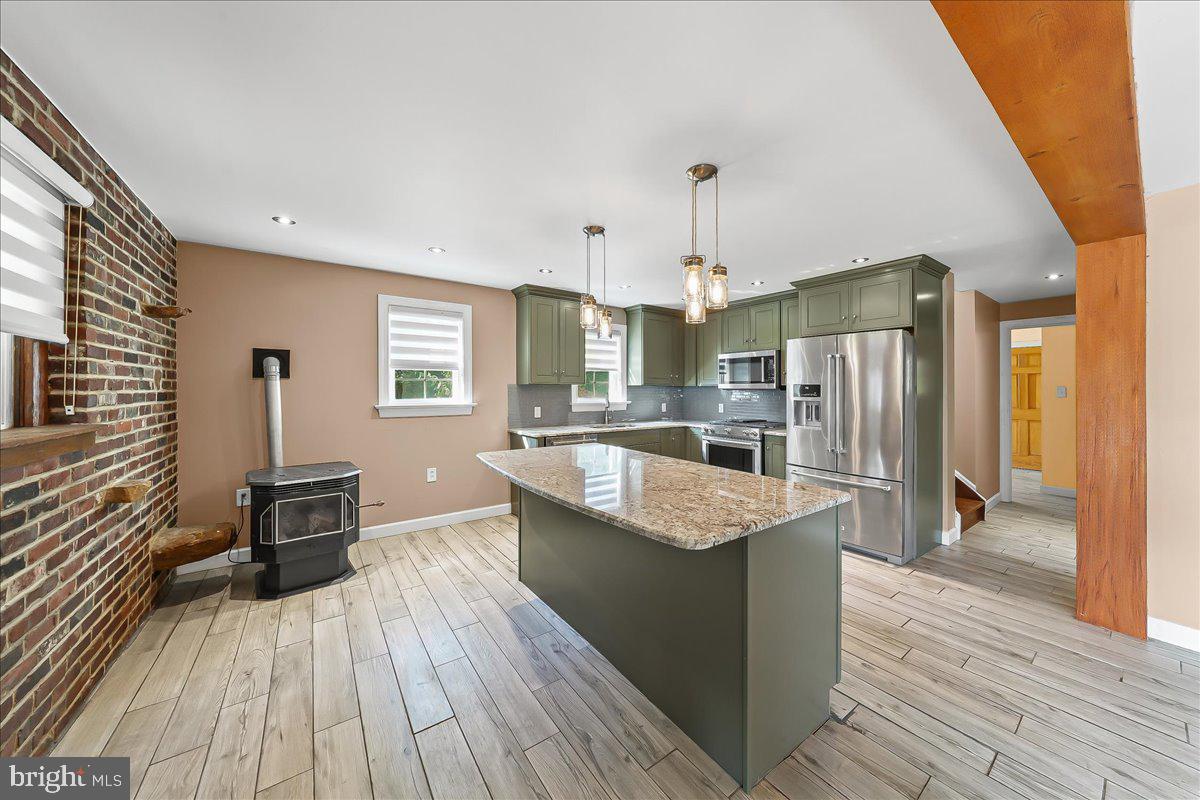756 Ewing Road Cochranville, PA 19330 - Photo 60 of 73 a kitchen with stainless steel appliances granite countertop a refrigerator a stove and a wooden floors