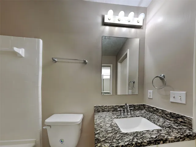 a bathroom with a sink a toilet and mirror