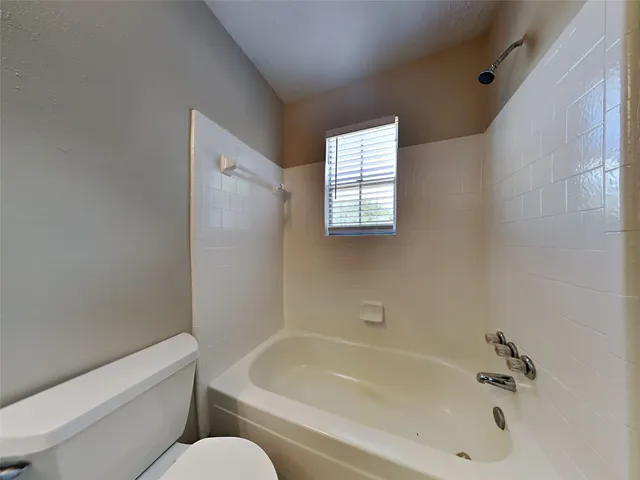 a white bath tub sitting next to a white toilet