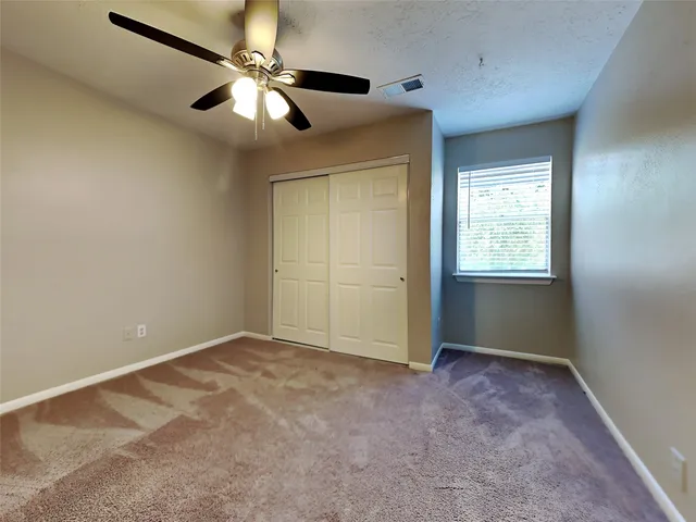 an empty room with closet and fan