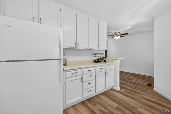 a kitchen with cabinets appliances and a wooden floor