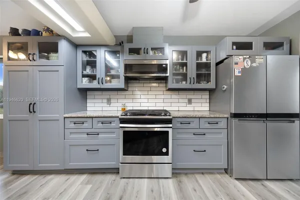 a kitchen with stainless steel appliances cabinets and wooden floor