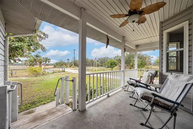 a view of a porch with furniture and a yard