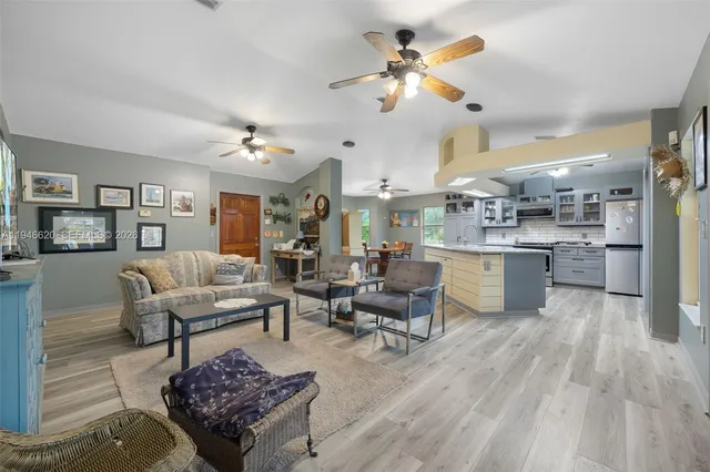 a living room with lots of furniture and kitchen view