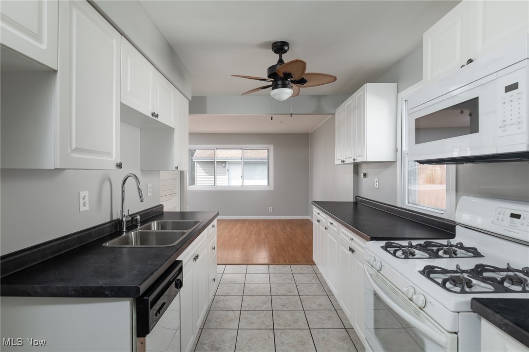 4782 Belle Meadow Road Mentor, OH 44060 - Photo 9 of 22 Kitchen with ceiling fan, white cabinets, sink, white appliances, and light wood-type flooring