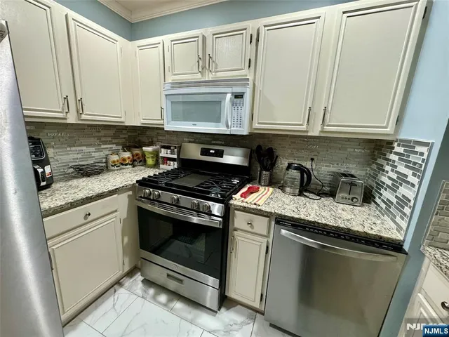a kitchen with stainless steel appliances granite countertop a refrigerator sink and stove