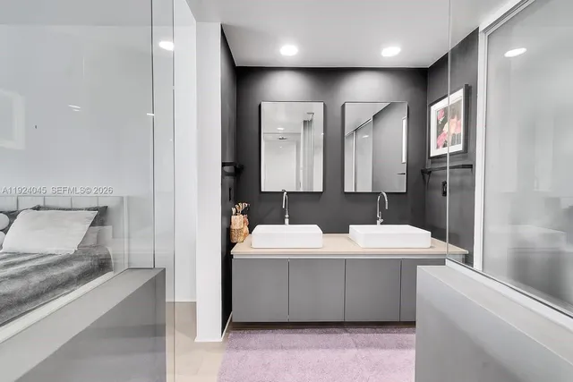 a bathroom with a double vanity sink a mirror and a bathtub