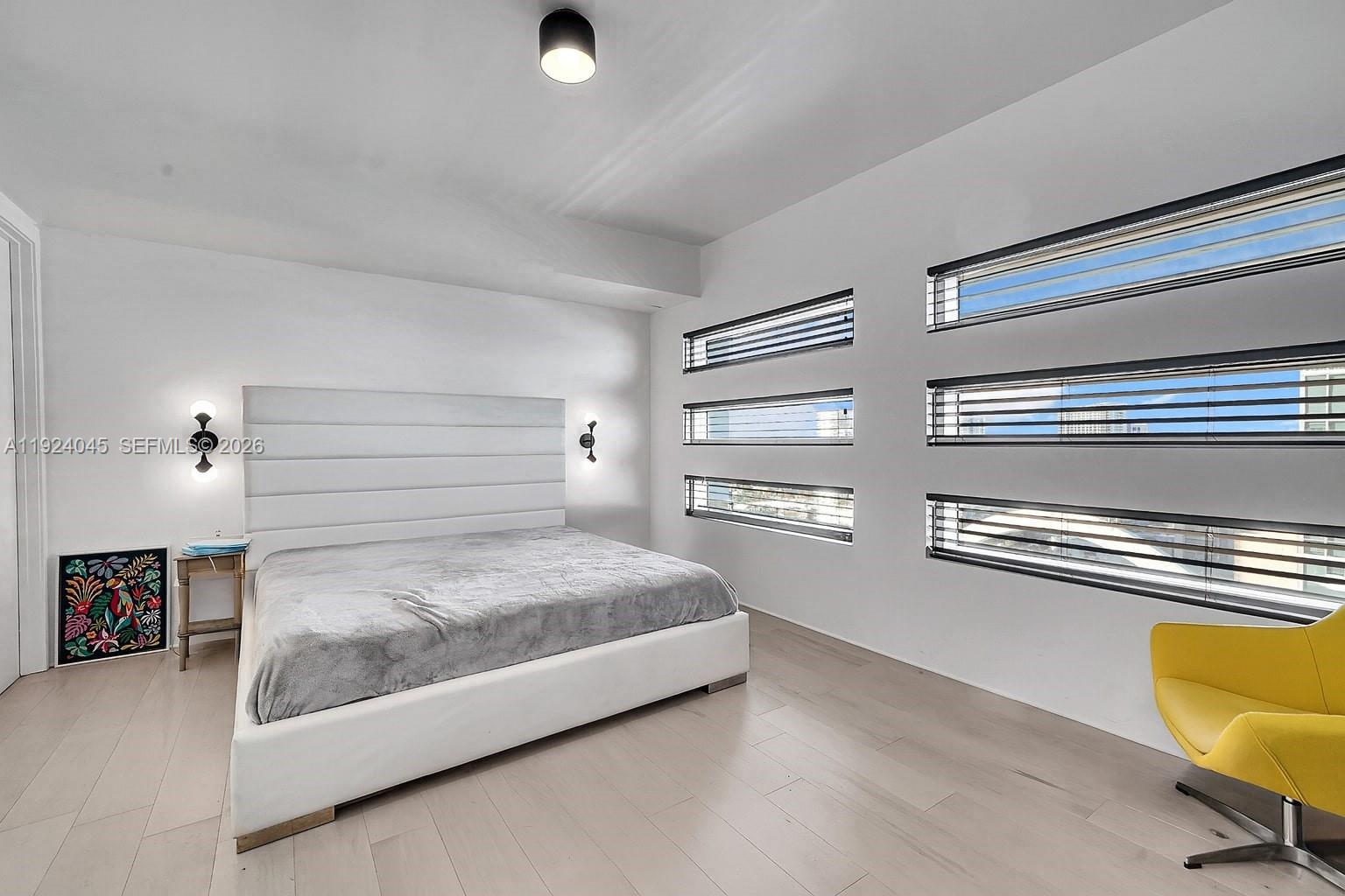 1040 Biscayne Boulevard, Unit 2603 Miami, FL 33132 - Photo 19 of 40 a bedroom with a bed and a chair