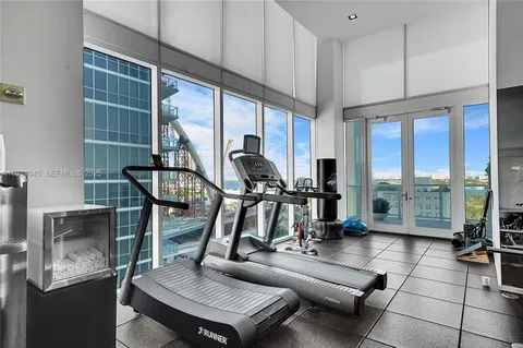 a room with gym equipment and large windows