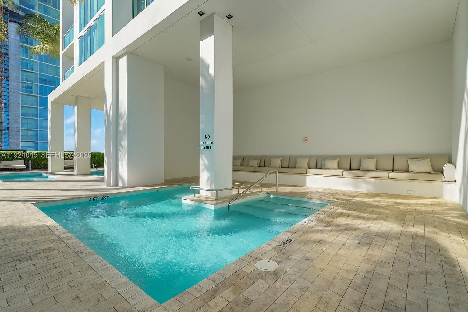 1040 Biscayne Boulevard, Unit 2603 Miami, FL 33132 - Photo 38 of 40 a view of a swimming pool with an outdoor space and seating area