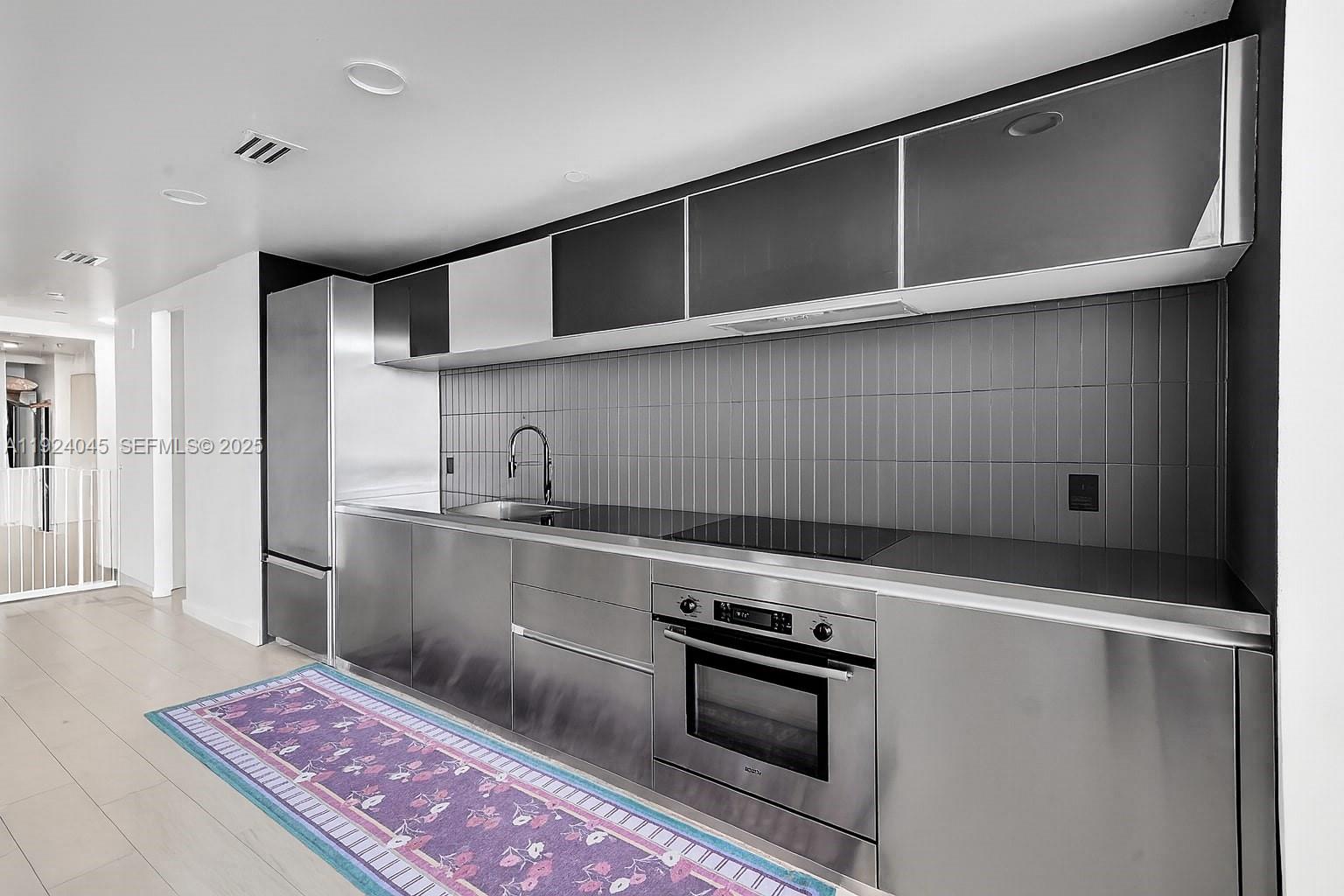 1040 Biscayne Boulevard, Unit 2603 Miami, FL 33132 - Photo 6 of 40 a kitchen with stainless steel appliances granite countertop a refrigerator and a stove